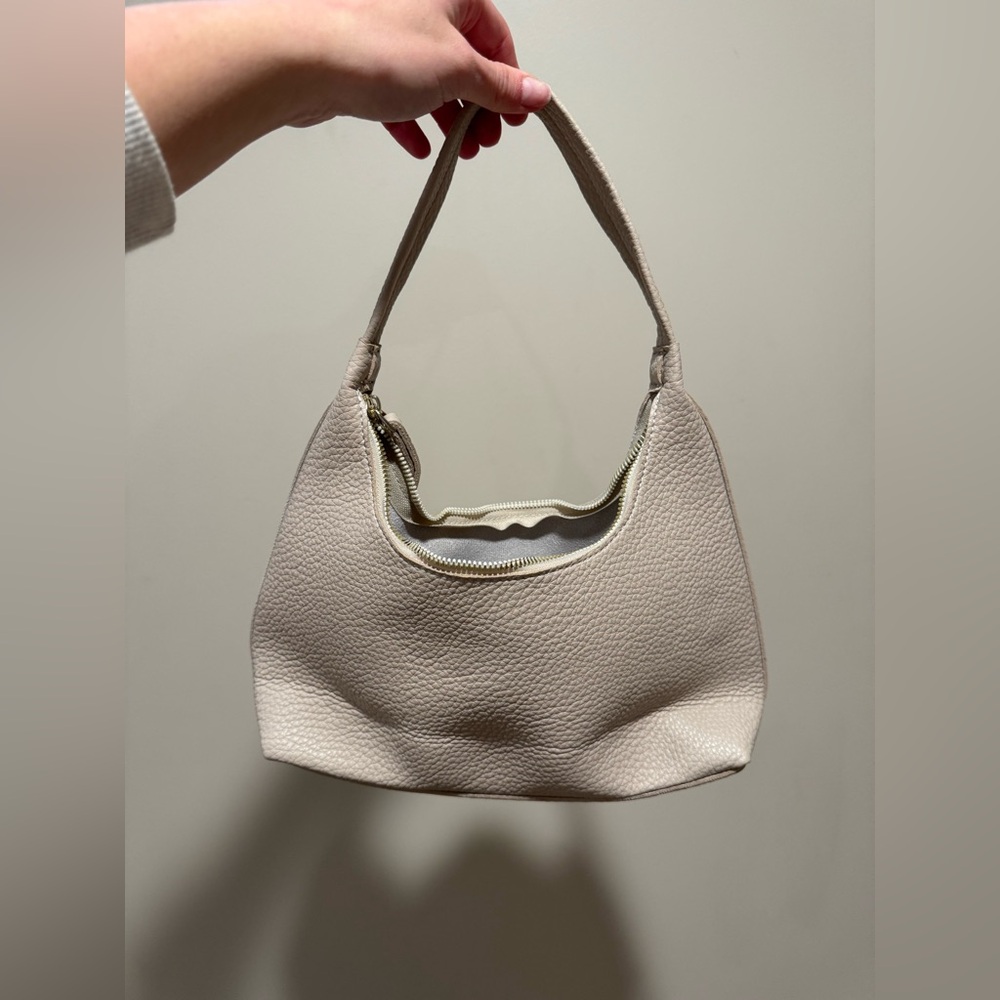 Cream colored shoulder bag.